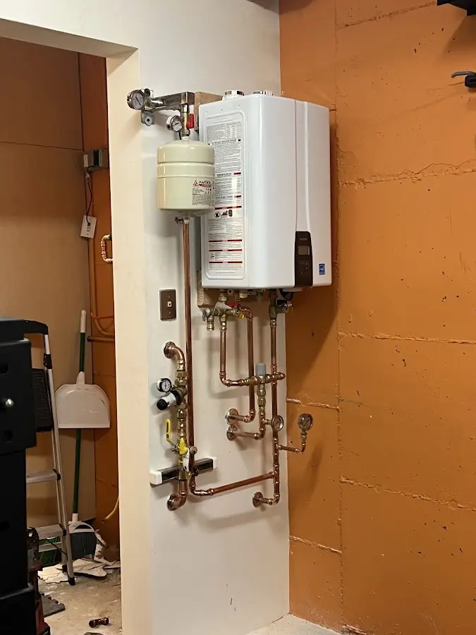 Plumbing technician inspecting water heater connections in Maitland